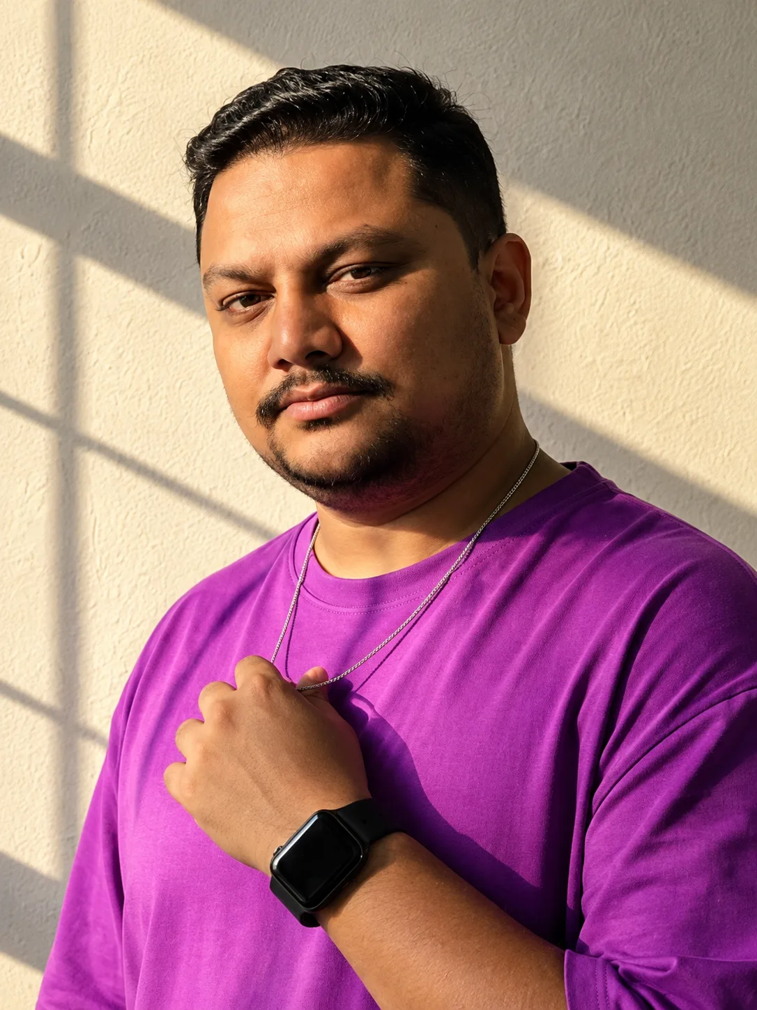 a hyper-realistic cinematic portrait of a confident man standing against a warm textured wall, illuminated by strong golden sunlight
