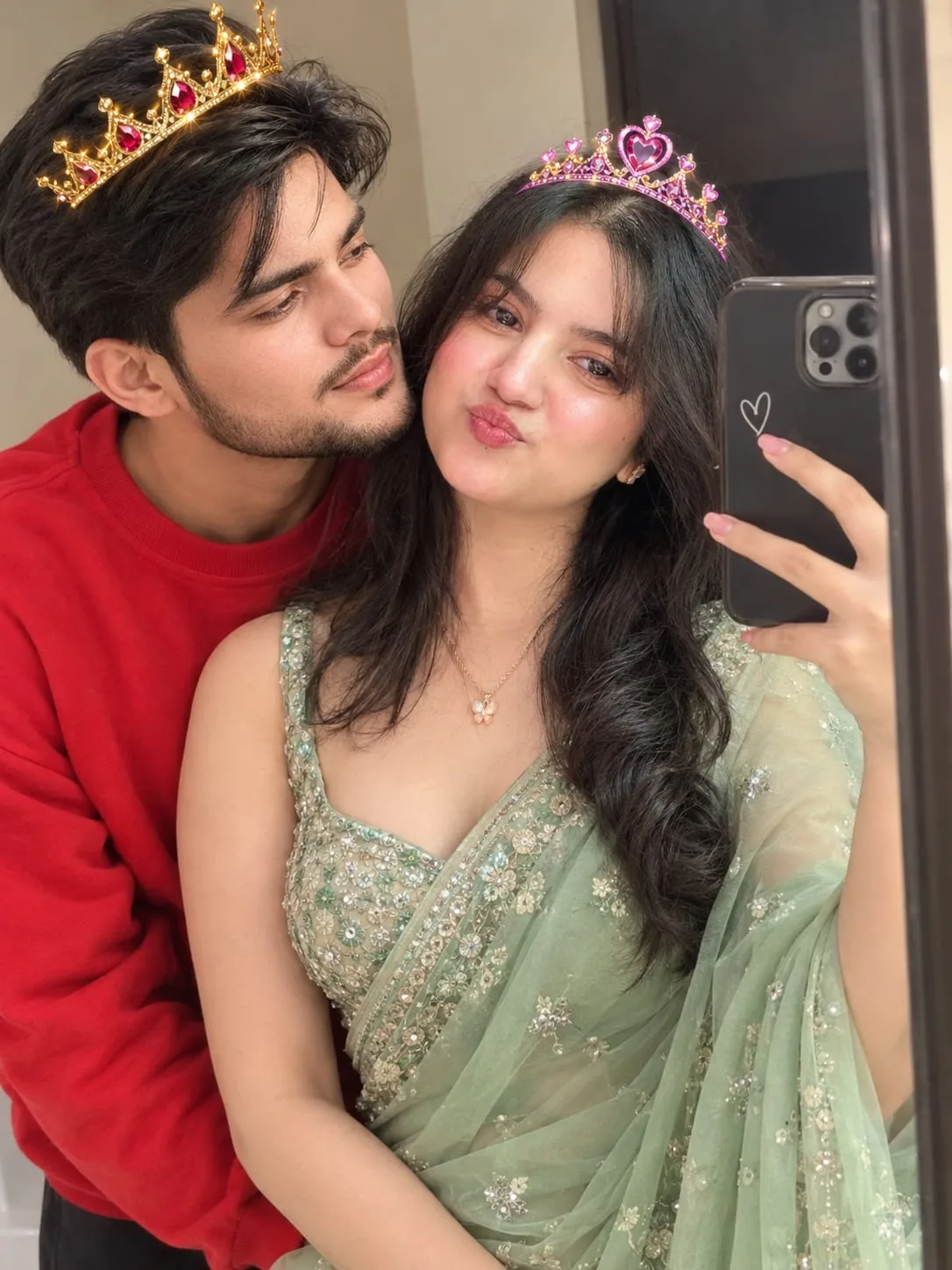 A high-quality, ultra-realistic photo capturing a candid moment of a young couple posing in front of a large, decorative wall mirror.